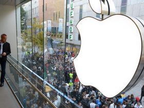 Customers queue to enter the Apple Store where a giant logo is displayed in the southern German city of Munich on September 21, 2012 as the iPhone 5 goes on sale. AFP PHOTO/CHRISTOF STACHE
