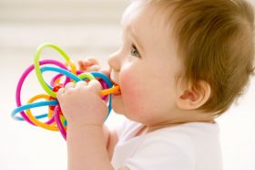 Baby girl chewing on teething ring