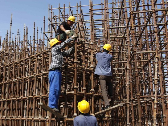 Construction workers erect scaffolding on a building site located on the outskirts of Beijing September 23, 2009. China's growing economic influence in the developing world merits a louder voice for Beijing in the international financial system, central bank governor Zhou Xiaochuan said in comments published on Wednesday. Zhou's remarks feed into a debate about how to redistribute voting power in institutions such as the International Monetary Fund (IMF) to better reflect the fast growth of big emerging economies including China.    REUTERS/David Gray       (CHINA BUSINESS POLITICS CONSTRUCTION)