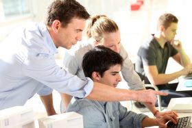 Students with teacher in front of desktop computer