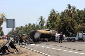 Firefighters work next to the charred wreckage of a fuel tanker truck and a passenger bus after an accident in Petacalco, in Guerrero state, Mexico, April 13, 2017. REUTERS/Stringer