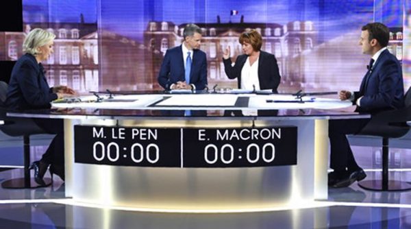 French presidential election candidate for the far-right Front National party, Marine Le Pen, left, French journalist Christophe Jakubyszyn, 2nd left, French journalist Nathalie Saint-Cricq, 2nd right, and French presidential election candidate for the En Marche ! movement, Emmanuel Macron, right, pose prior to the start of a live broadcast face-to-face televised debate in La Plaine-Saint-Denis, north of Paris, France, Wednesday, May 3, 2017 as part of the second round election campaign. Pro-European progressive Emmanuel Macron and far-right Marine Le Pen are facing off in their only direct debate before Sunday's presidential runoff election. (Eric Feferberg/Pool Photo via AP)