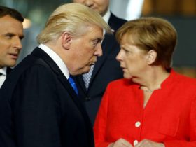 U.S. President Donald Trump (C) walks past French President Emmanuel Macron (L) and German Chancellor Angela Merkel on his way to his spot for a family photo during the NATO summit at their new headquarters in Brussels, Belgium May 25, 2017.  REUTERS/Jonathan Ernst - RTX37MR4