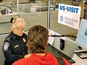 Homeland Security Secretary Tom Ridge, (L) watches Customs and Border Protection officer Mary Armbrust(C) use the new US-VISIT biometric program at Hartsfield-Jackson International Airport in Atlanta, Georgia, 05 January 2004. The system fingerprints and photographs visitors to the United States who require visas. Erik S. Lesser/Getty Images/AFP PHOTO / FOR NEWSPAPER AND TV USE ONLY