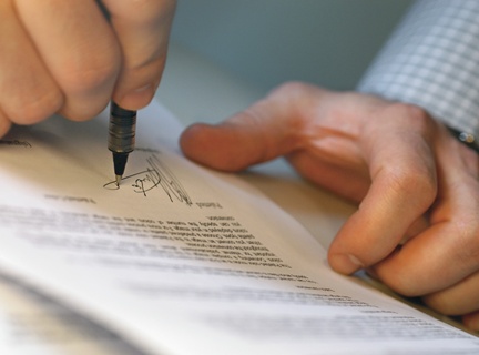 Man's Hands Signing Document --- Image by © Royalty-Free/Corbis