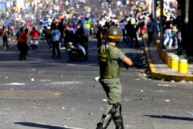 Students clash with National Guards members during an opposition demontration against the government of Venezuelan President Nicolas Maduro, in Caracas on February 12, 2014. Unidentified assailants on a motorcycle fired into a crowd of anti-government protesters, leaving at least two people wounded and a pro-government man dead. AFP PHOTO / LEO RAMIREZ (Photo credit should read LEO RAMIREZ/AFP/Getty Images)